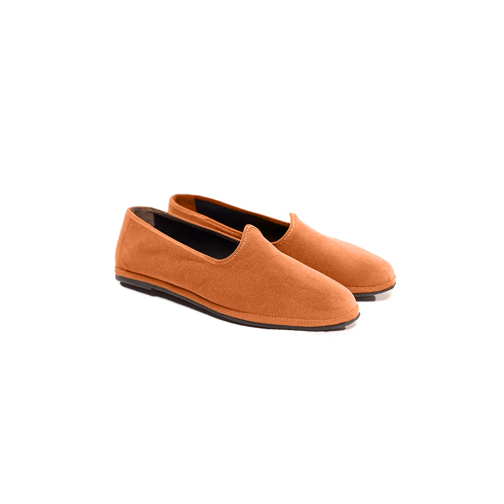 Pair of orange loafers on a white background